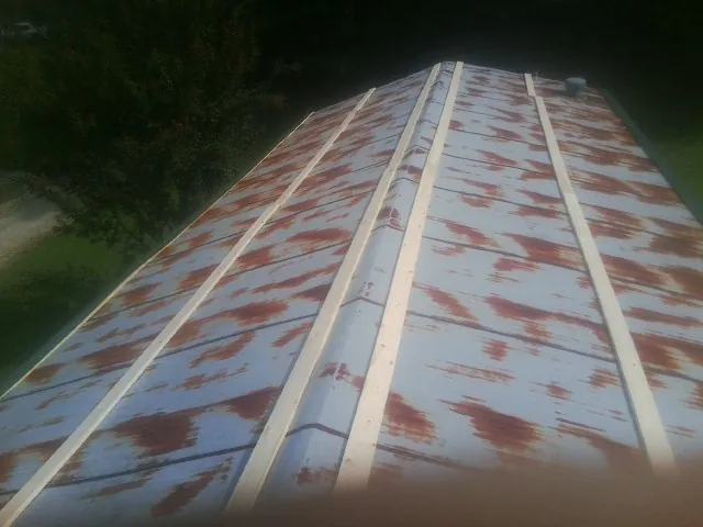 Rusted metal roof panels with new wood purlins before replacement — Storm Damage Roof Repair in Imler by Roofing Brothers