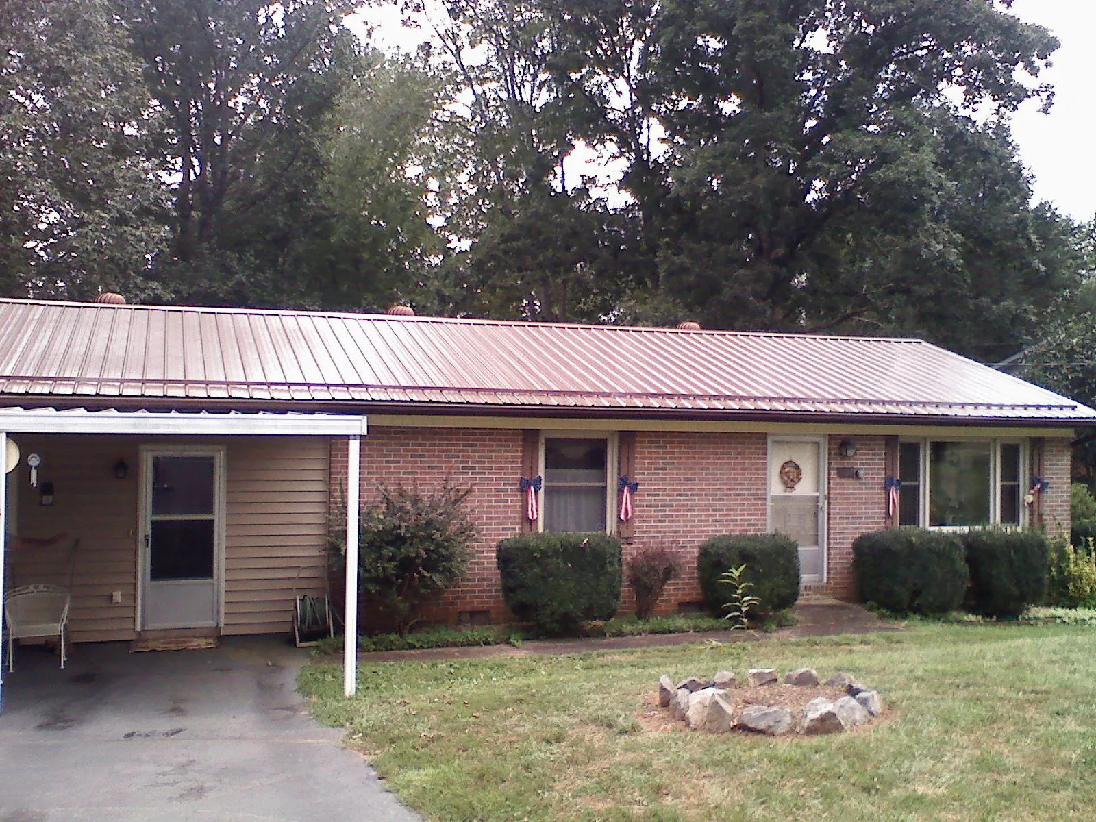 Bronze metal roof and carport on a brick ranch home — Roof Repair work by our crew in Imler
