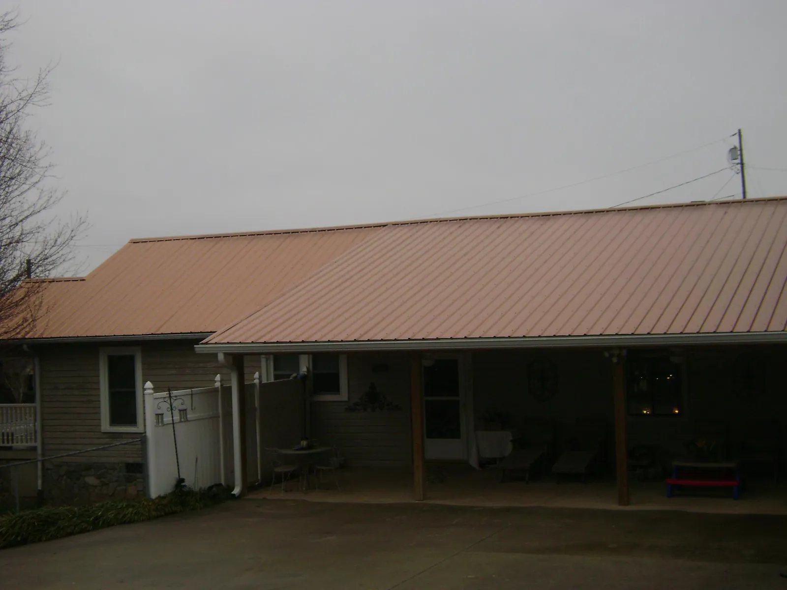 Copper toned metal roof over a wide covered patio in Imler